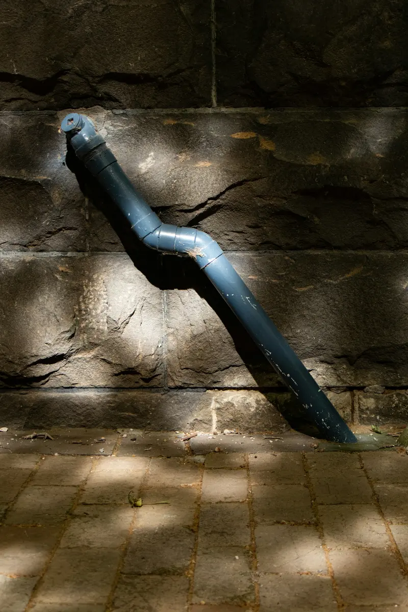 Pipe passing through a cracked stone wall